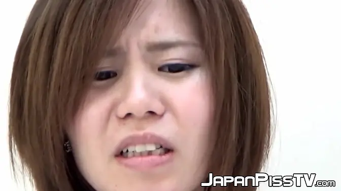 An adorable Japanese brunette soaks her panties with warm pee