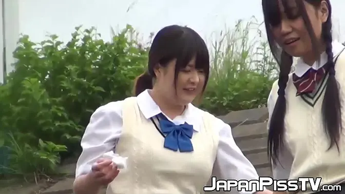 Two young Japanese schoolgirls compete in outdoor pissing contest