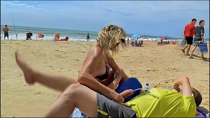 Milf makes stranger ejaculate with skillful handjob right on the beach