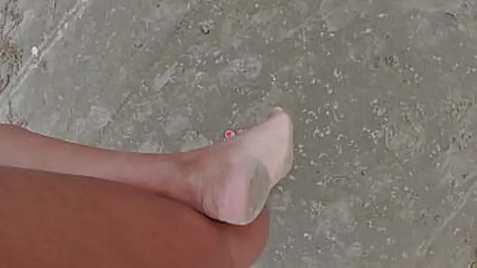 Sultry woman walks barefoot on beach and street