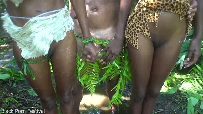 Two dark-skinned African tribe girls please the village chief in the forest