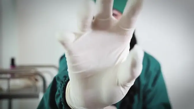 Nurse strips off rubber gloves while teasing with medical tools