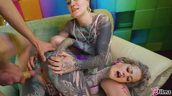 Two heavy inked babes get ass-fucked by a huge cock