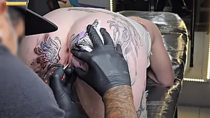 Hot sexy brunette gets her anal tattoo highlighted in public